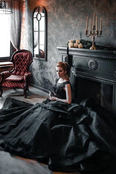 Приваблива жінка в чорному платті в середньовічному інтер'єрі — стокове фото