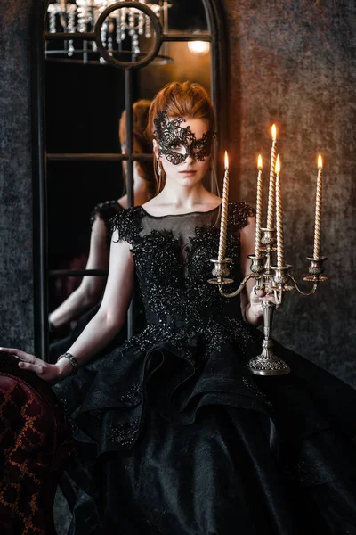 Attractive woman in black dress in medieval interior — Stock Photo, Image