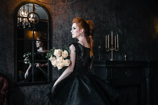 Привлекательная женщина в черном платье в средневековом интерьере — стоковое фото