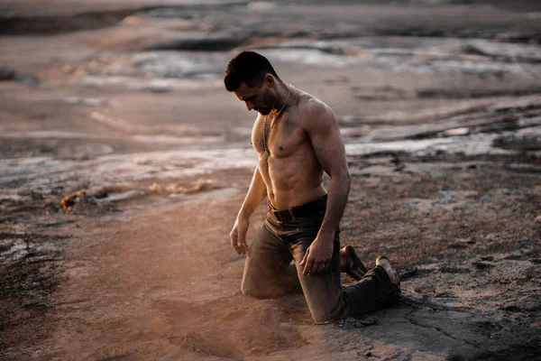 Atractivo hombre bronceado en la arena negra —  Fotos de Stock