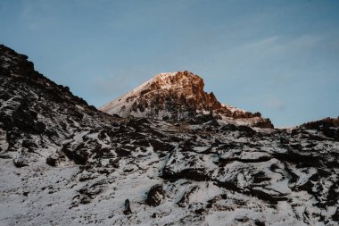 Bir yama bir kar bir parçası üzerinde parlayan güneş kaplı dağ Stokksnes, İzlanda.