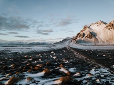 Bir dağ bir kar üzerinden doğru giden bir yol Stokksnes, İzlanda manzara kaplı. Fotoğraf bir dron kullanarak alınır.
