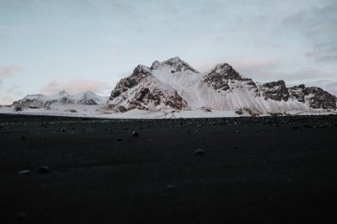 Siyah kum plaj önünde kar kaplı dağlar Stokksnes, İzlanda.