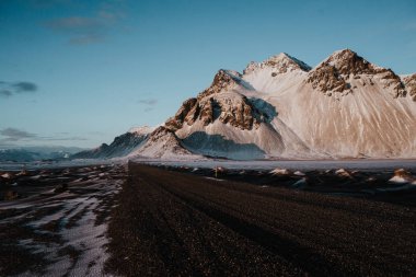 Gün batımında Stokksnes, İzlanda karlı bazı alanların yanındaki patikadan.