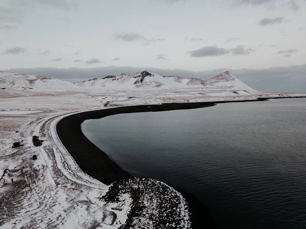 Uma Praia Areia Preta Lado Uma Paisagem Coberta Neve Islândia — Fotografia de Stock