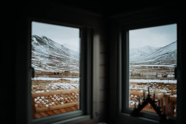Looking through the window of a cabin onto a landscape in Snaefellsnes, Iceland.