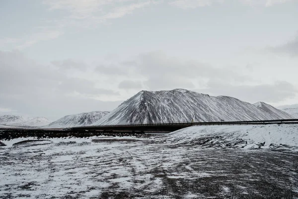 一座桥穿过积雪覆盖的 Snaefellsnes 冰岛的风景 免版税图库照片