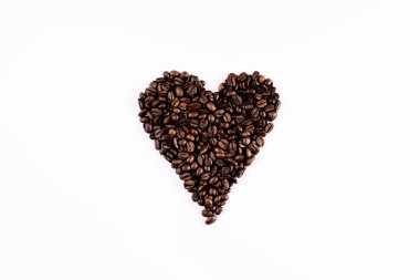 Kahve çekirdekleri beyaz arka planda kalp oluşturur.