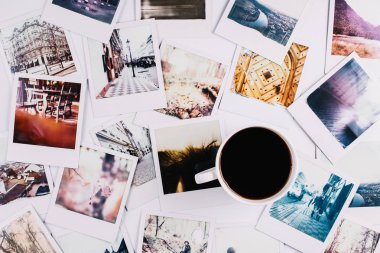 Bir avuç polaroid arasında duran kahve fincanı.
