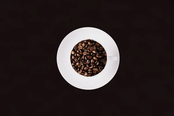 Kubek Wypełniony Ziarnem Kawy Talerz Pod Spodem Ciemnym Tle — Zdjęcie stockowe
