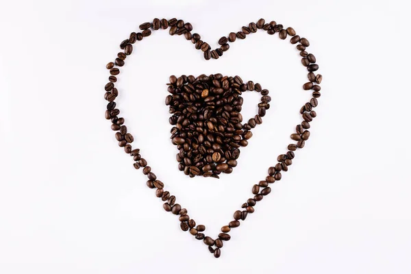 白い背景にマグカップとハートを形成するコーヒー豆 — ストック写真