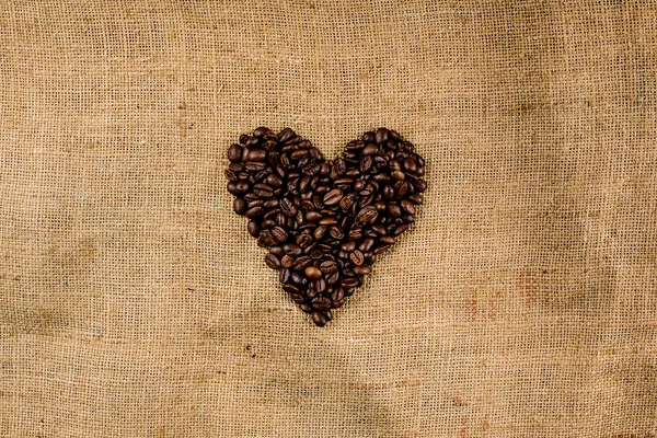 茶色にハートを形成するコーヒー豆 構造化された背景 — ストック写真