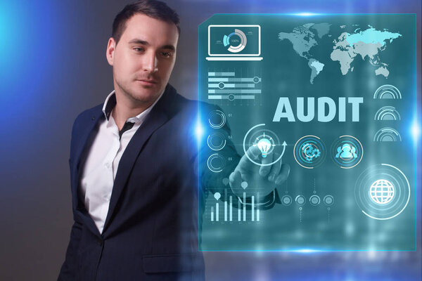 Business, Technology, Internet and network concept. Young businessman working on a virtual screen of the future and sees the inscription: Audit