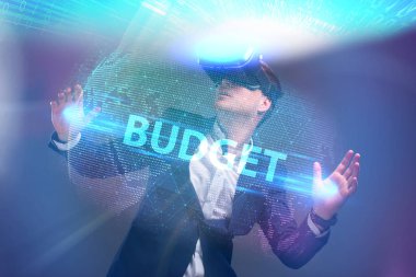 Ekonomi, teknoloji, Internet ve ağ kavramı. Sanal gerçeklik Gözlükte çalışan genç iş adamı görür Yazıt: bütçe