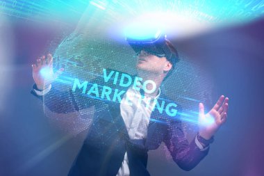 Ekonomi, teknoloji, Internet ve ağ kavramı. Sanal gerçeklik Gözlükte çalışan genç iş adamı görür Yazıt: Video pazarlama