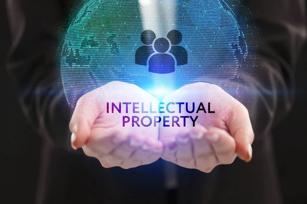 İş, teknoloji, internet ve şebeke kavramı. Genç bir girişimci geleceğin sanal ekranı üzerinde çalışıyor ve yazıyı görüyor: fikri mülkiyet