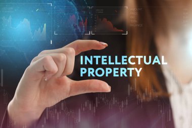 İş, teknoloji, internet ve şebeke kavramı. Genç bir girişimci geleceğin sanal ekranı üzerinde çalışıyor ve yazıyı görüyor: fikri mülkiyet