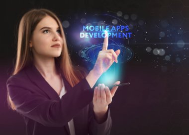 İş, teknoloji, Internet ve ağ kavramı. Geleceğin sanal bir ekranda çalışan genç bir girişimci ve yazıt görür: mobil uygulamaları geliştirme
