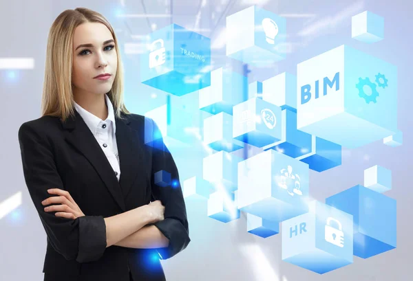 İş, Teknoloji, İnternet ve ağ konsepti. Genç işadamı geleceğin sanal ekranı üzerinde çalışıyor ve BIM yazısını görüyor.