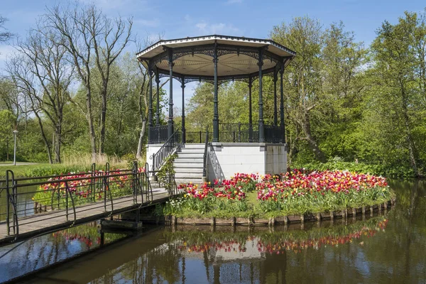 bridge with beautiful  park kiosk and tulips in Vondelpark in Amsterdam, Netherlands