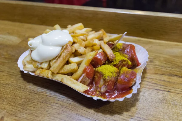Oluşan Currywurst denilen bilinen berliner çanak buğulama ve köri ketçap ve searved ile patates kızartması terbiyeli dilimler halinde kesip domuz sosisi kızarmış