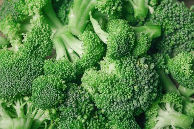 Kahverengi tabakta bir sürü taze yeşil brokoli, ahşap arka planda..