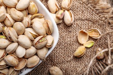 Bazı bütün Antep fıstığı (seçici odak; yakın çekim shot) ahşap arka plan üstünde göster