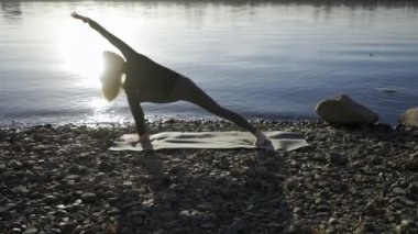 Yoga kadın kalan nehir banka ve meditatting.