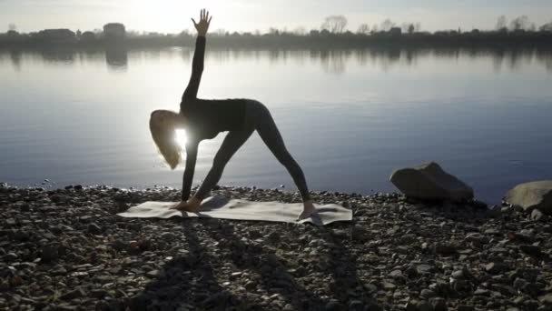 Yoga woman staying on the river bank and meditatting. — Stock Video