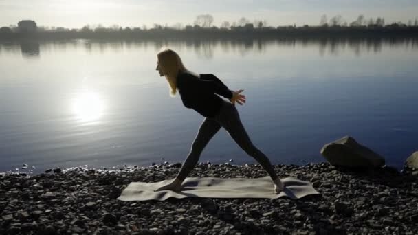 Yoga-Frau bleibt am Flussufer und meditiert. — Stockvideo