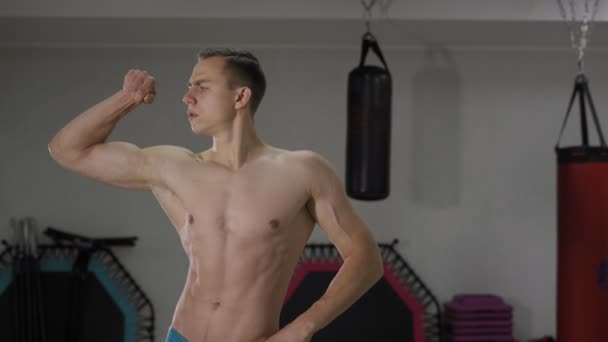 Человек показывает свои мускулы — стоковое видео