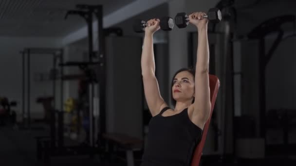 Mujer joven en forma en el gimnasio haciendo ejercicio de levantamiento de pesas — Vídeos de Stock