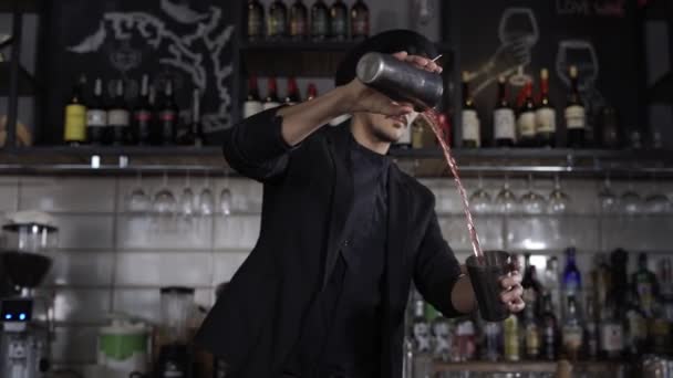 Бармен наливает алкогольный коктейль через фильтр — стоковое видео