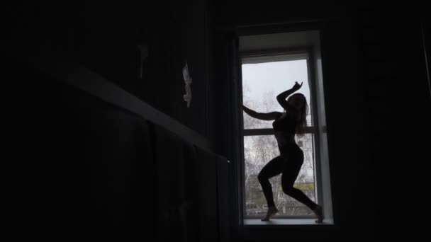 Молодая гимнастка на черном фоне — стоковое видео