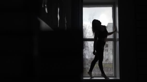 Молода дівчина гімнастка на чорному тлі — стокове відео