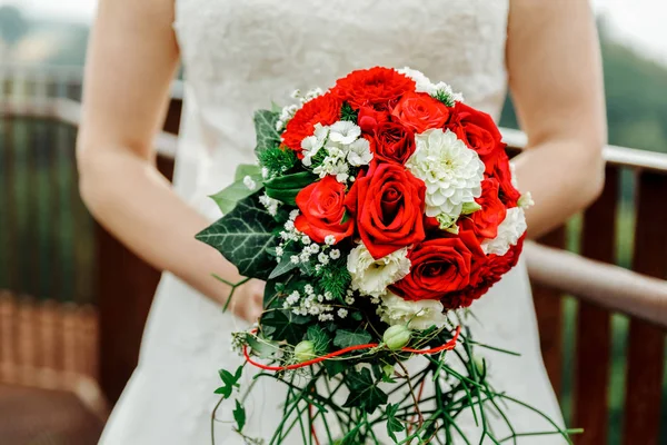 Handed wedding bouquet with roses and greenery