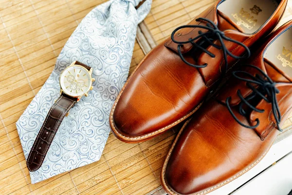 Close-up van de bruidegom schoenen, horloges en gelijkspel. Klaar. lichte achtergrond — Stockfoto