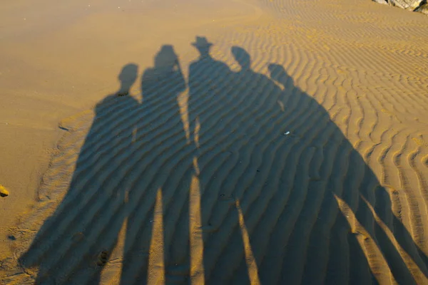 Familjens silhuetter på en sand — Stockfoto