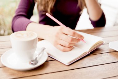 Kadının elleri defter kafede, yazma. Blogger'ın yaşam