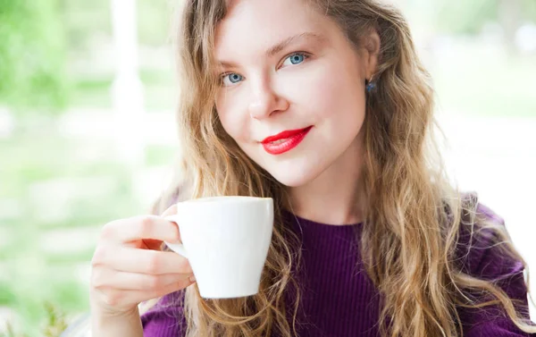 Güzel kadın kırmızı dudaklı beyaz fincan kahve koşullarının portresi.