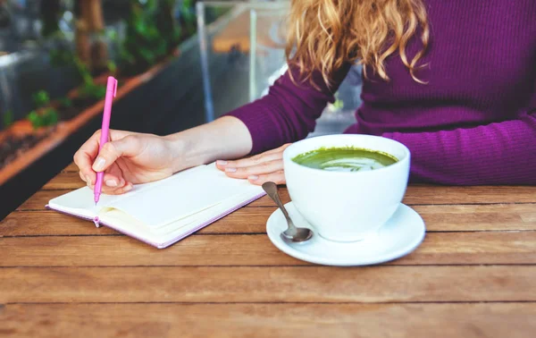 Kadının eller letephone holding ve defter, city café'yazma. Blogger'ın yaşam tarzı