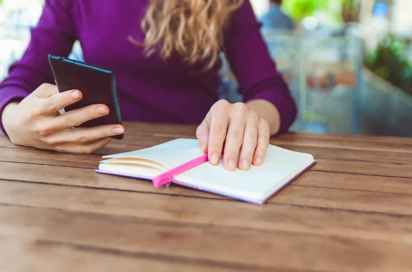 Frauenhände Die Das Telefon Der Hand Halten Und Notizbüchern Schreiben — Stockfoto