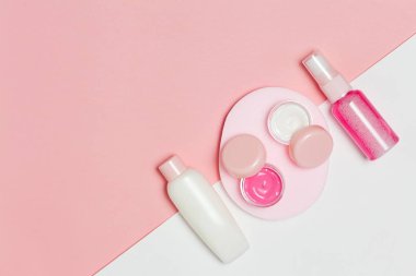 Güzel Dekoratif kozmetik ve kremler, pembe arka plan ayarlamak. Metniniz için boşaltmak. Minimalizm kozmetik tarzı. Üstten Görünüm, düz yatıyordu.