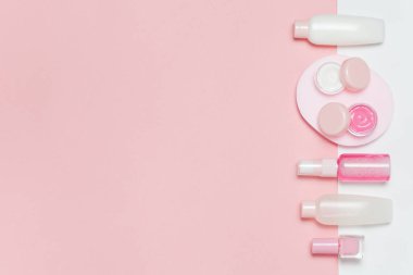 Güzel Dekoratif kozmetik ve kremler, pembe arka plan ayarlamak. Metniniz için boşaltmak. Minimalizm kozmetik tarzı. Üstten Görünüm, düz yatıyordu.