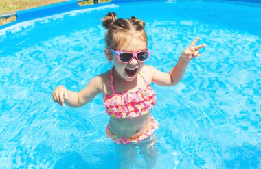 Yüzme Havuzu Float güneş gözlüklü ve having fun halka, şirin ve komik küçük kız yüzme havuzunda. Smmer yaşam tarzı kavramı