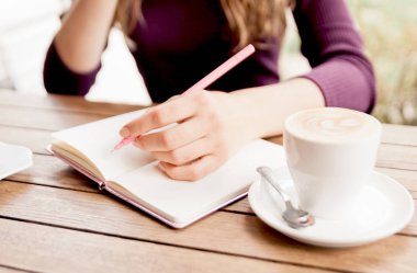 Kadının elleri defter kafede, yazma. Blogger'ın yaşam