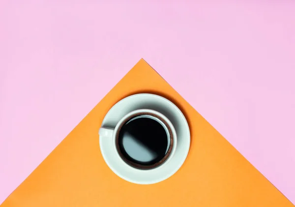 Flat lay of minimalistic picture of coffee on pink and yellow background. Minimalism coffee concept.