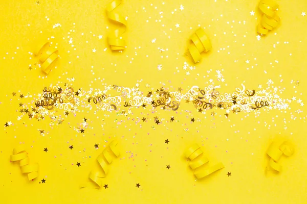 Creative confetti background. Stars and sparkles on yellow background. top view, flat lay. Bright and festife