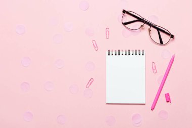 Not defteri veya Not defteri gözlüklerle pembe backgriund. Yaratıcı minimalizm mahkeme kavramı. Üstten görünüm, düz yatıyordu.