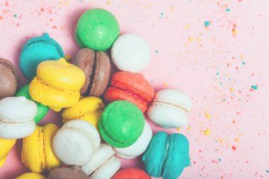 Tatlı metin eklemek için kopya alanı ile yumuşak pembe Kağıt arka plan üzerinde renkli mini macarons grubudur. Üstten görünüm, düz yatıyordu.